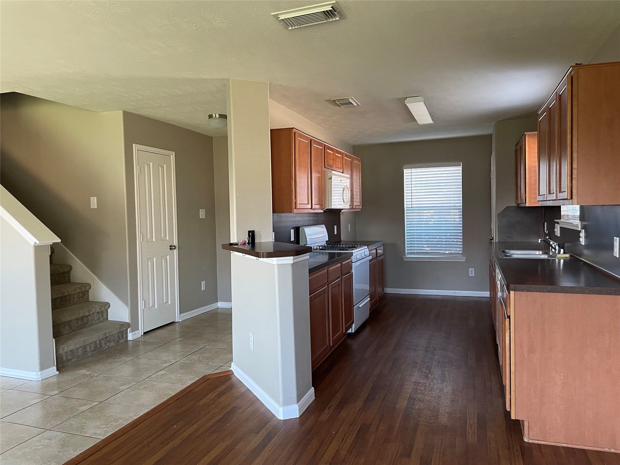 8103 Katie Mill Trail Spring, TX 77379 - Photo 23 of 36 a kitchen with granite countertop wooden floors and white stainless steel appliances