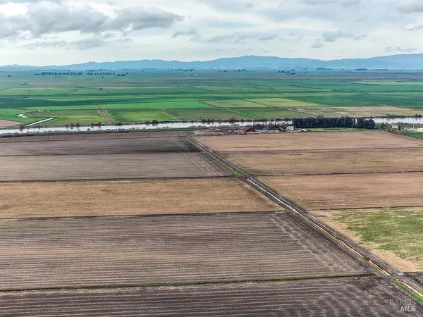a view of a house with a yard and large trees