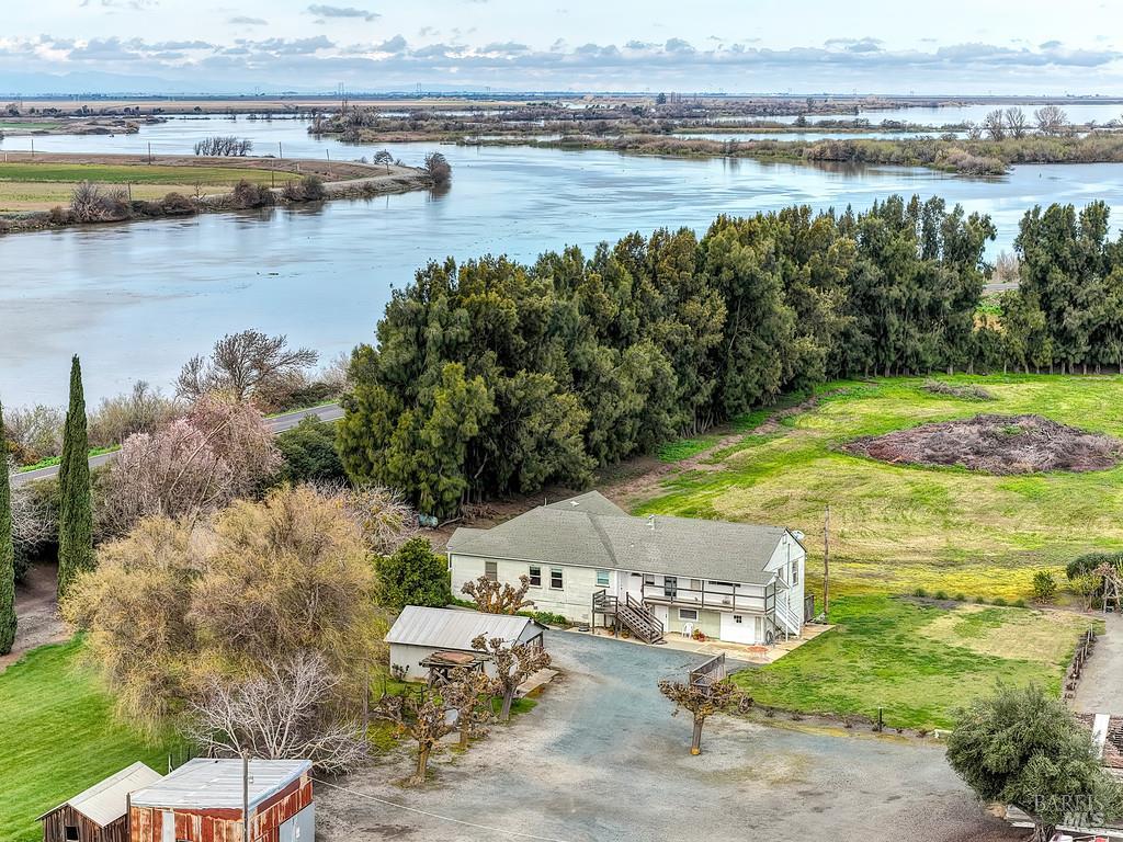 3834 Highway 84 Walnut Grove, CA 95690 - Photo 33 of 84 a view of a lake with lawn chairs and large trees