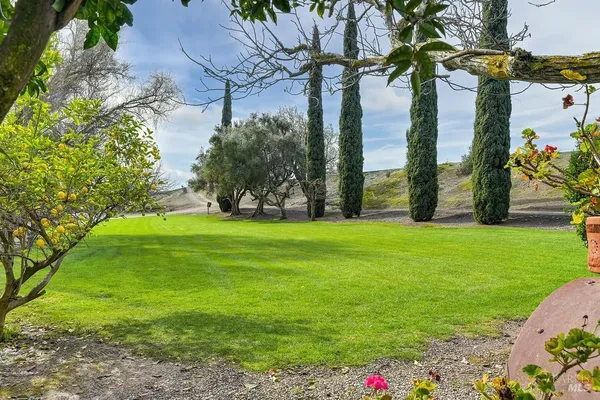 a kitchen with stainless steel appliances granite countertop a stove top oven a sink dishwasher a dining table and chairs with wooden floor