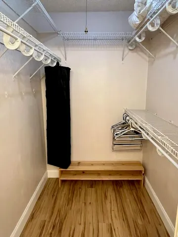 a view of walk in closet with clothes