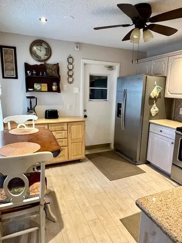 a workspace with stainless steel appliances kitchen island granite countertop a stove and a sink