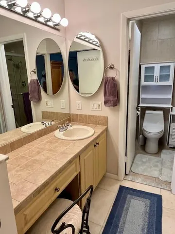 a bathroom with double vanity and a mirror