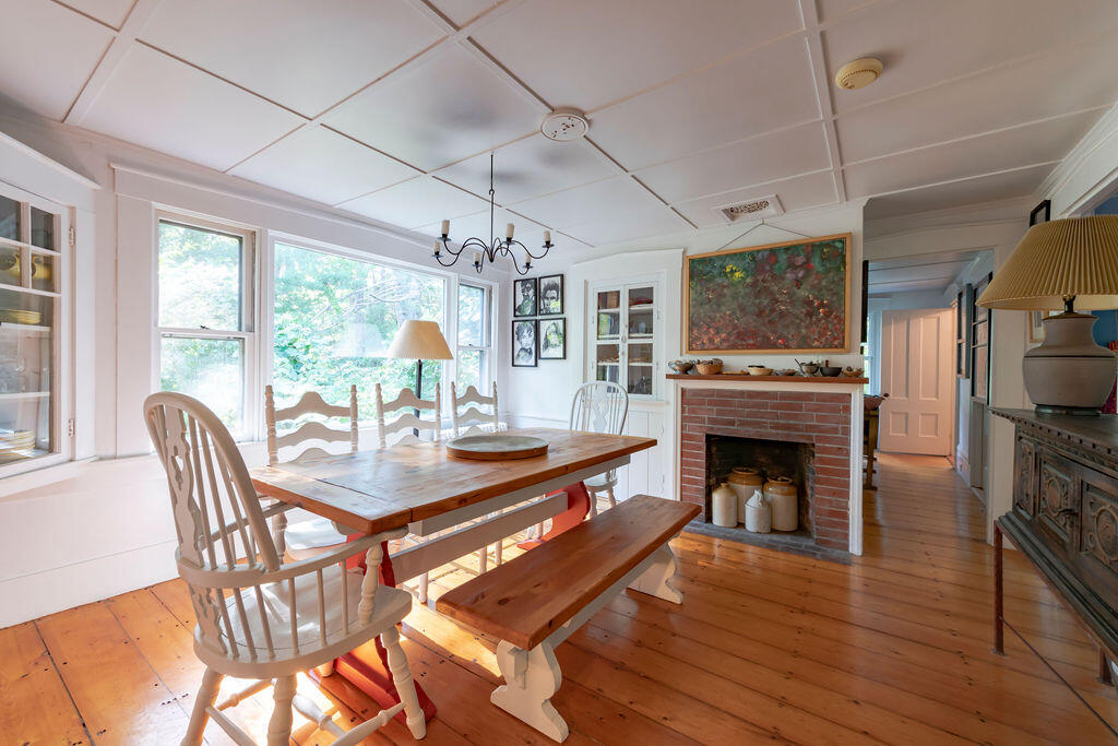 160 Paine Hollow Road Wellfleet, MA 02667 - Photo 15 of 71 a dining room with furniture a fireplace and wooden floor