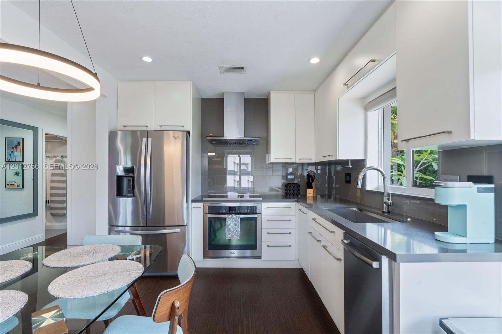 4370 Southwest 11th Street Miami, FL 33134 - Photo 13 of 21 a kitchen with stainless steel appliances granite countertop a sink a stove a refrigerator cabinets and dining table