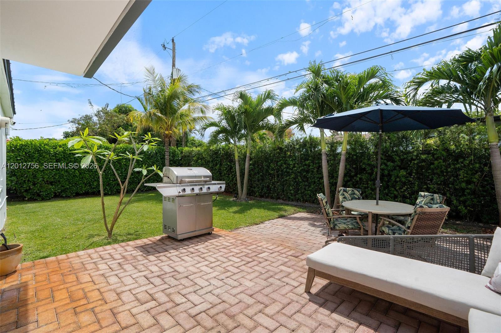 4370 Southwest 11th Street Miami, FL 33134 - Photo 6 of 21 a view of a patio with table and chairs potted plants and palm trees