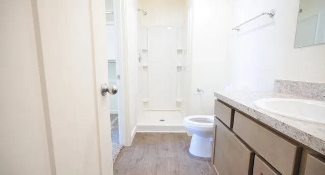 a bathroom with a granite countertop sink toilet and shower