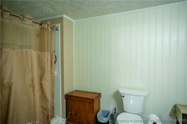 a white toilet sitting next to a shower curtain