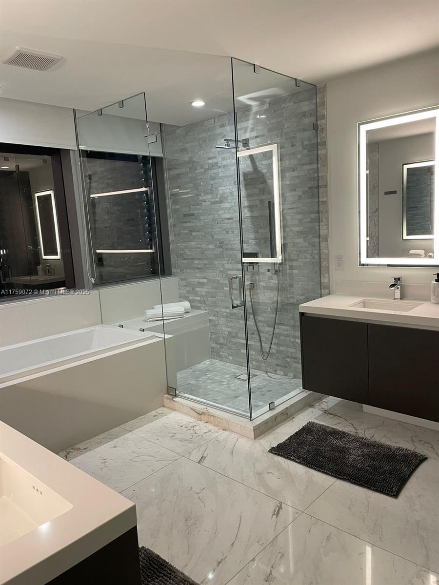 851 Northeast 1st Avenue, Unit 1401 Miami, FL 33132 - Photo 11 of 38 a bathroom with a bathtub and a sink