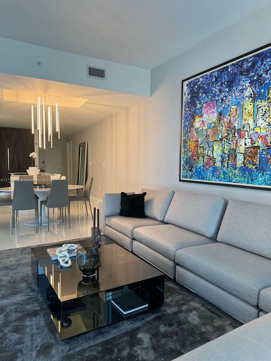 851 Northeast 1st Avenue, Unit 1401 Miami, FL 33132 - Photo 15 of 38 a living room with furniture a rug and a painting on the wall