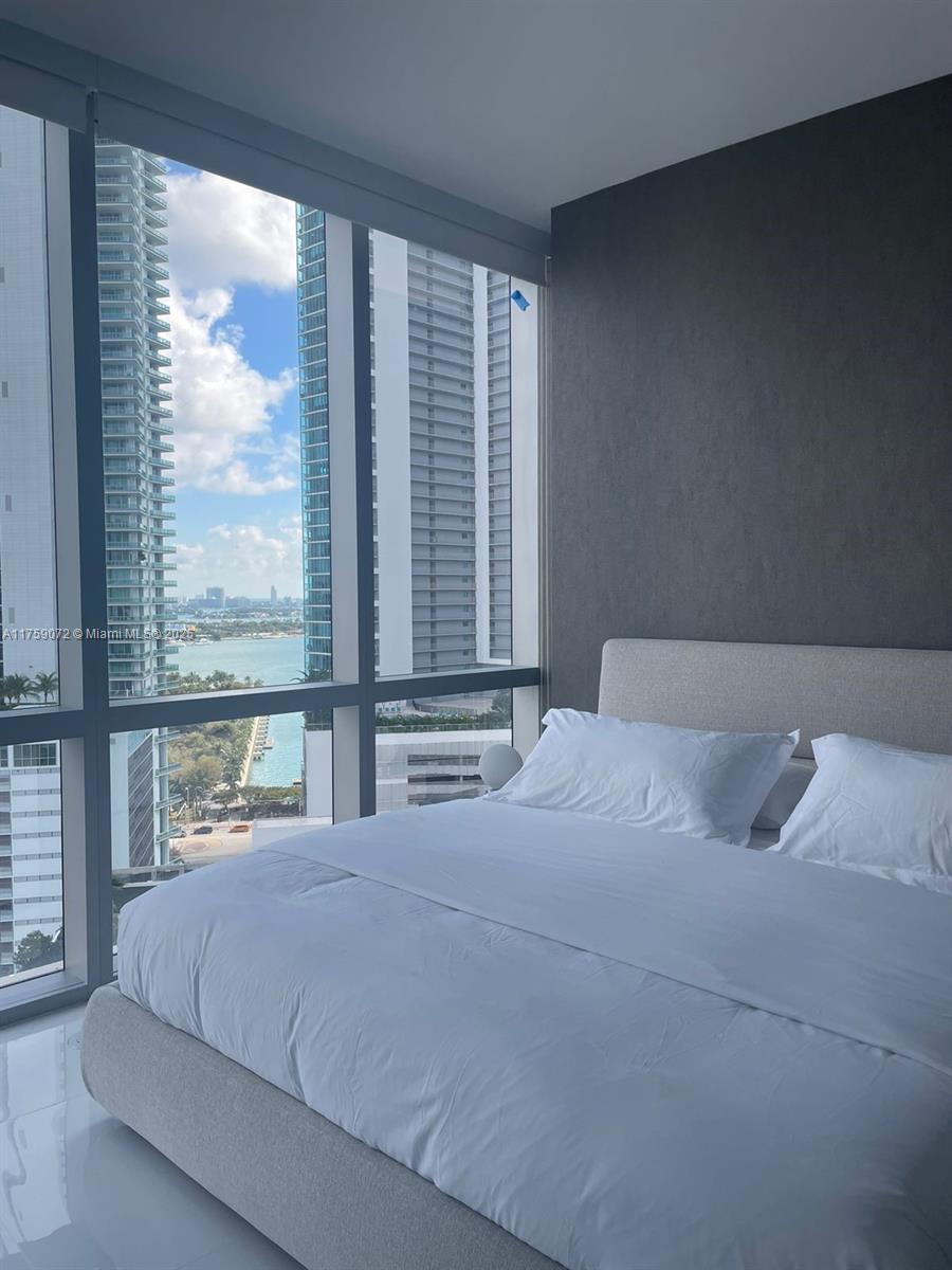 851 Northeast 1st Avenue, Unit 1401 Miami, FL 33132 - Photo 10 of 38 a bedroom with a large bed and a large window