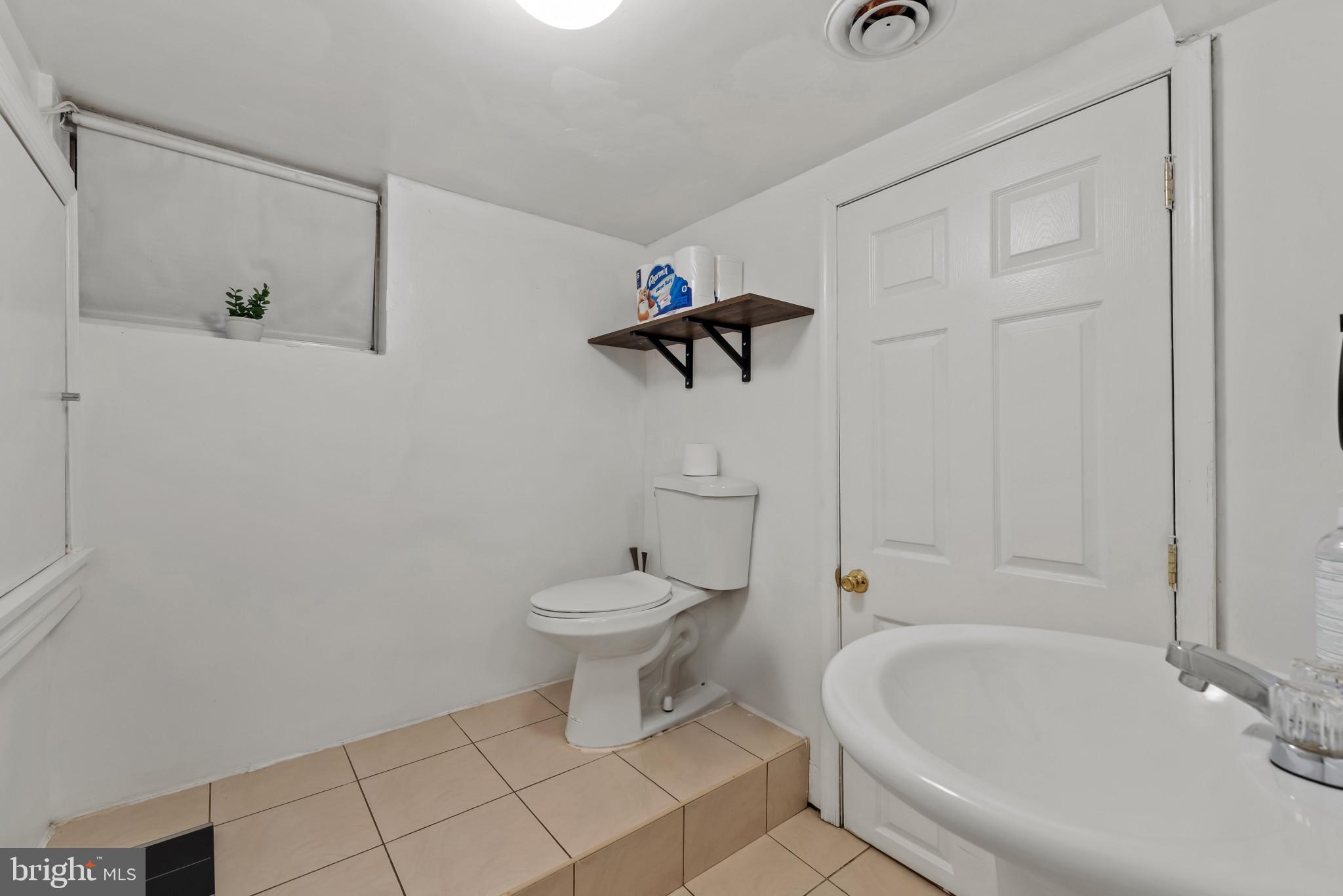 1807 East Lombard Street Baltimore, MD 21231 - Photo 23 of 30 a bathroom with a toilet a sink and bathtub