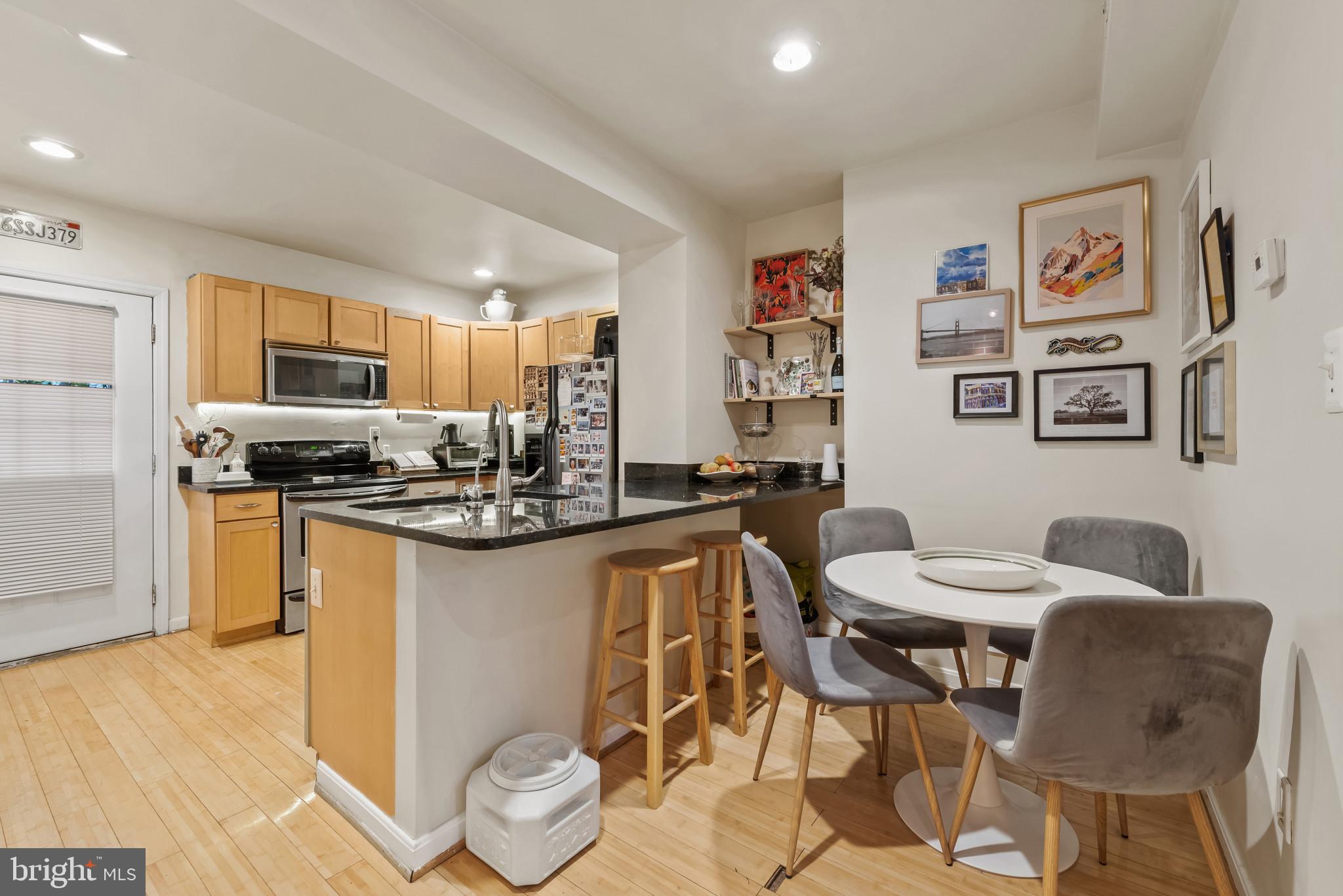 1807 East Lombard Street Baltimore, MD 21231 - Photo 7 of 30 a kitchen with stainless steel appliances kitchen island granite countertop a sink and cabinets
