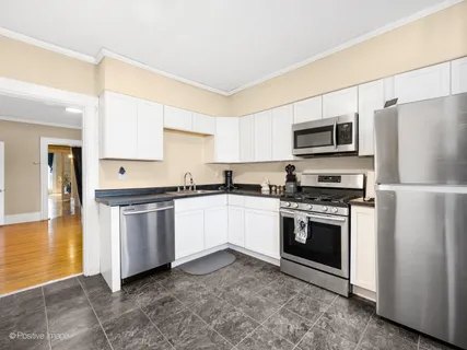 a kitchen with granite countertop a refrigerator stove and microwave