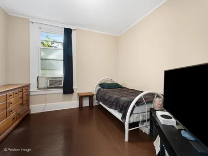 a bedroom with a bed and a flat tv screen on the dresser
