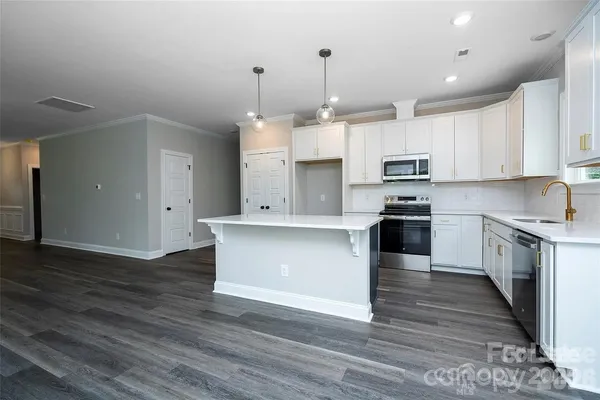 a large kitchen with stainless steel appliances granite countertop a stove a sink and a refrigerator