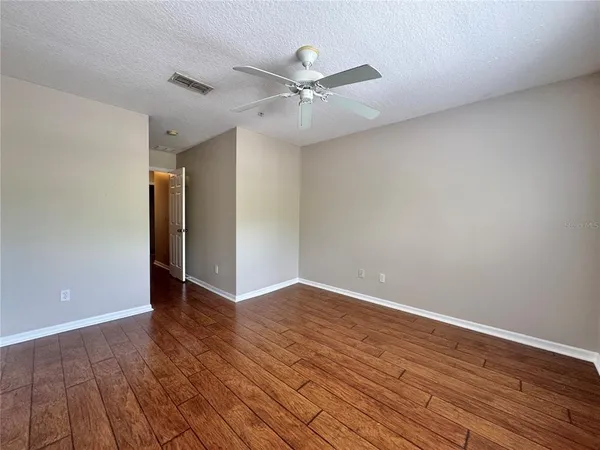 a view of an empty room with wooden floor