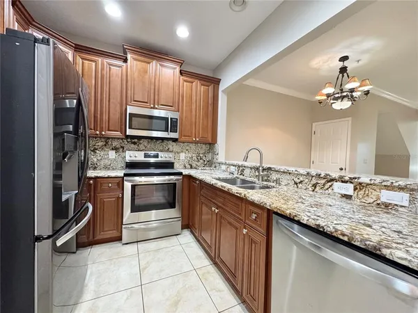 a kitchen with granite countertop a sink stainless steel appliances and cabinets
