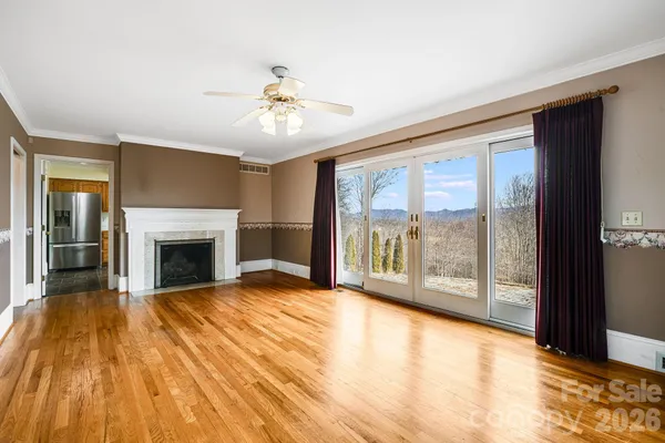 a view of an empty room with a fireplace and a window