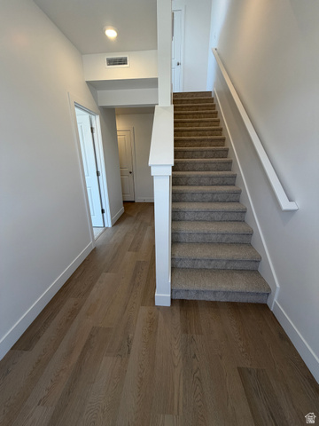 915 West Gold Ridge Ln Street St. George, UT 84790 - Photo 8 of 30 Entryway featuring wood-finish flooring, a carpeted staircase with white risers, and contemporary white walls