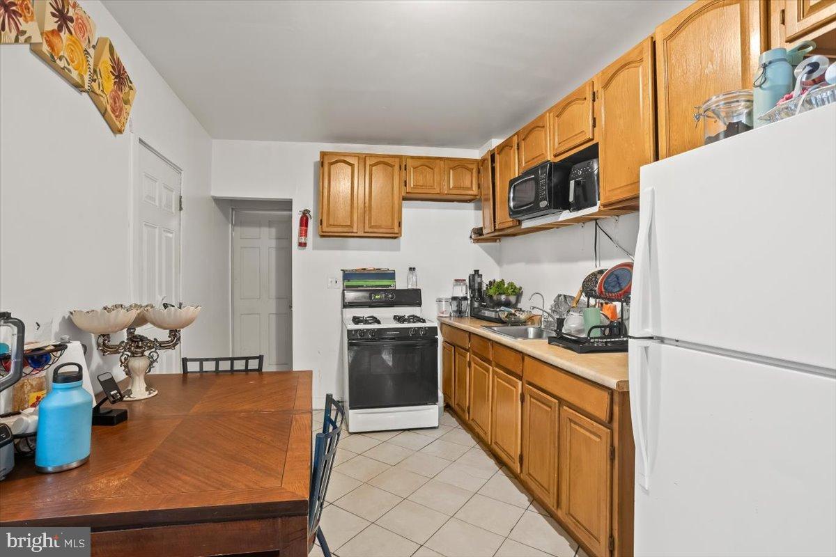 1302 North 11th Street Reading, PA 19604 - Photo 7 of 16 a kitchen with stainless steel appliances granite countertop a sink stove and refrigerator