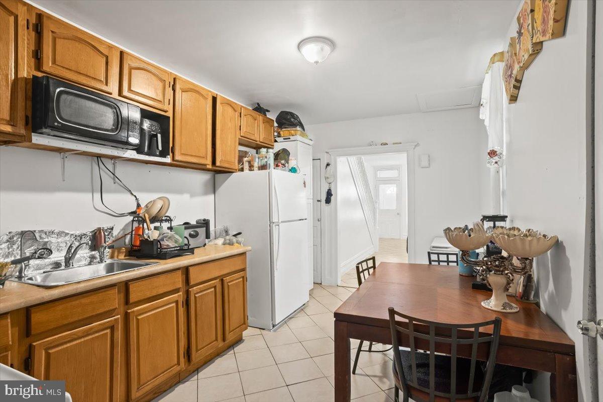 1302 North 11th Street Reading, PA 19604 - Photo 8 of 16 a kitchen with stainless steel appliances a table chairs and a refrigerator