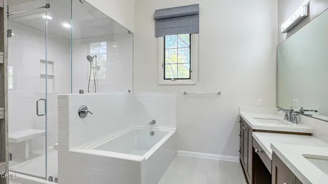 a bathroom with a tub sink and mirror