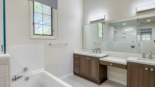 a spacious bathroom with a tub sink and mirror