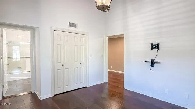 an empty room with wooden floor cabinet and windows