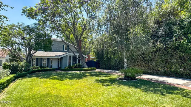 a view of a house with a big yard and large trees