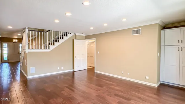 a view of an empty room with wooden floor