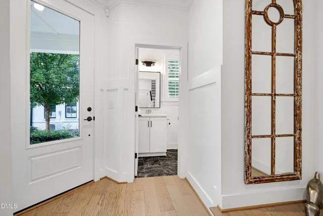a bathroom with a toilet a sink a mirror and a window