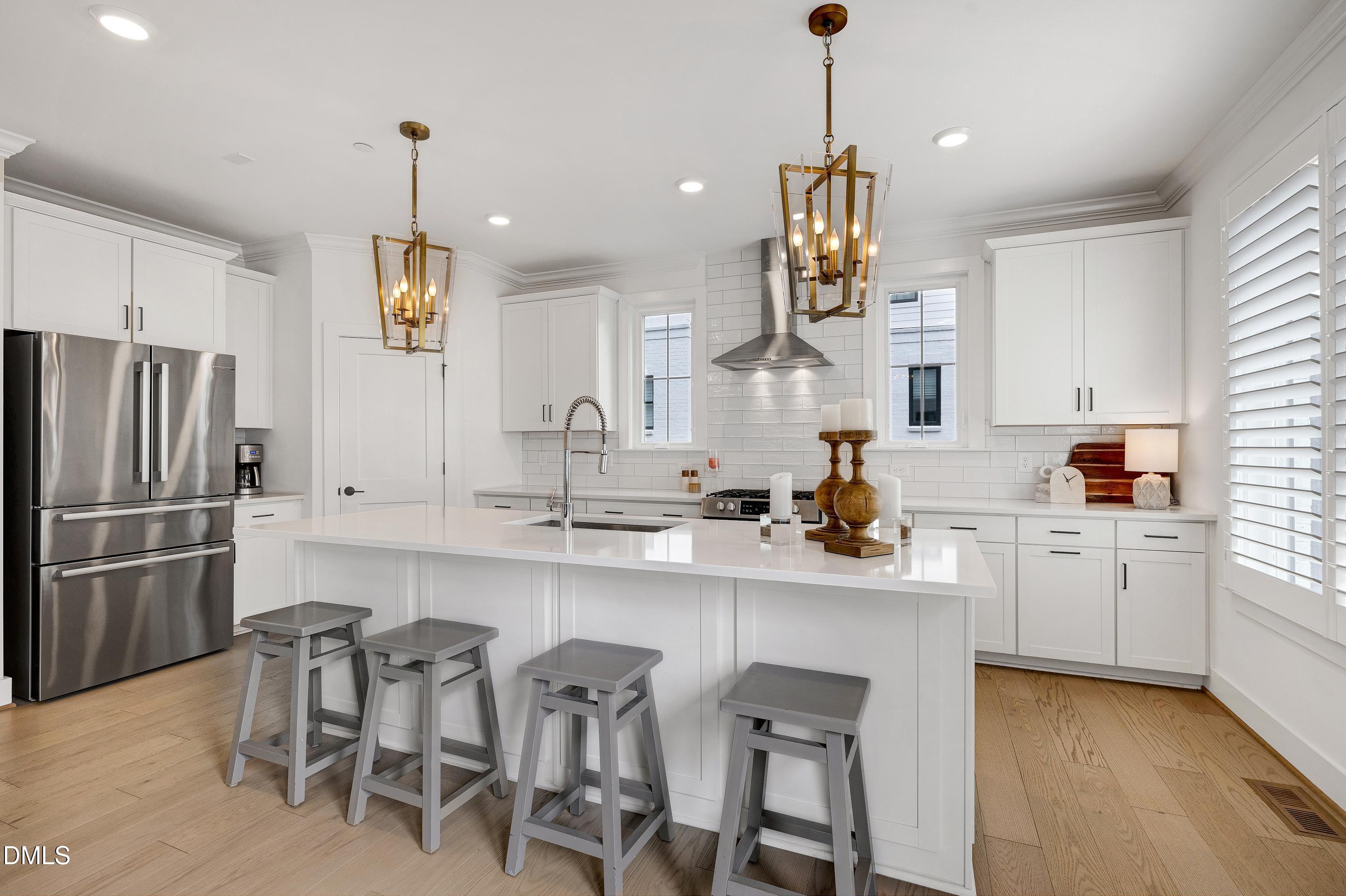 400 Bryan Pointe Drive, Unit 104 Raleigh, NC 27608 - Photo 23 of 66 a kitchen with white cabinets and stainless steel appliances