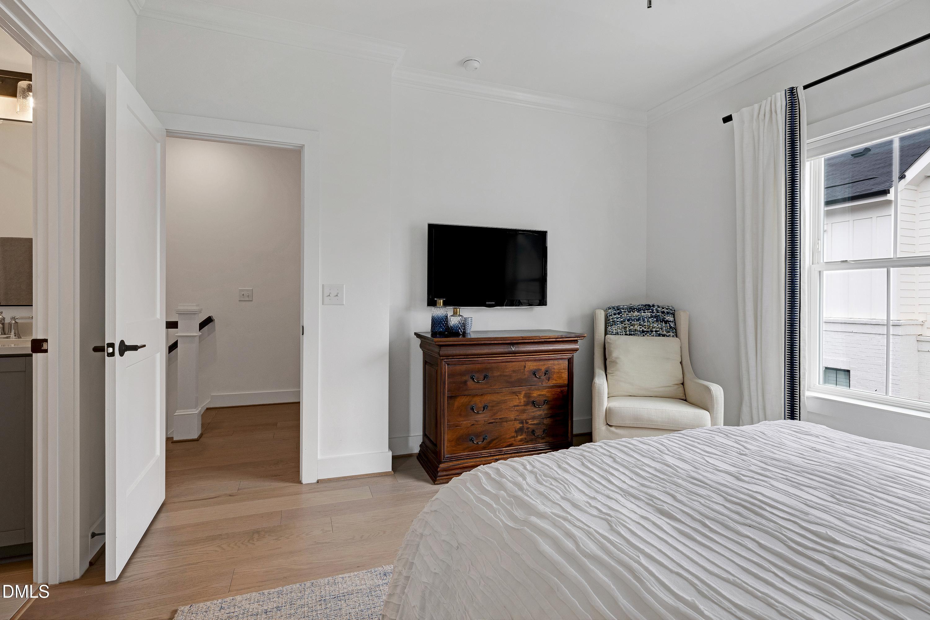 400 Bryan Pointe Drive, Unit 104 Raleigh, NC 27608 - Photo 44 of 66 a bedroom with a bed and a flat tv screen in it