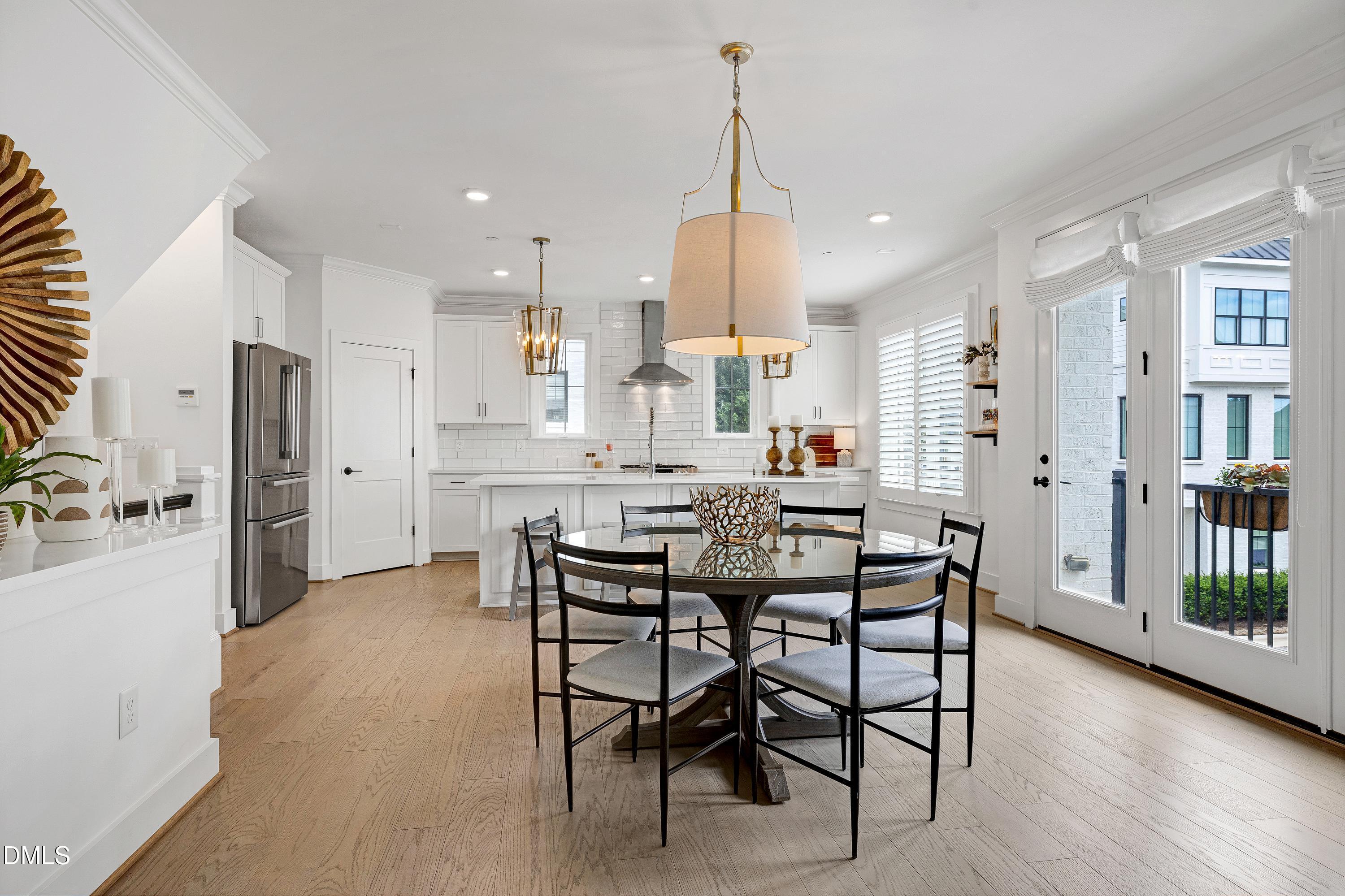 400 Bryan Pointe Drive, Unit 104 Raleigh, NC 27608 - Photo 46 of 66 a kitchen with stainless steel appliances kitchen island granite countertop a table chairs and a refrigerator