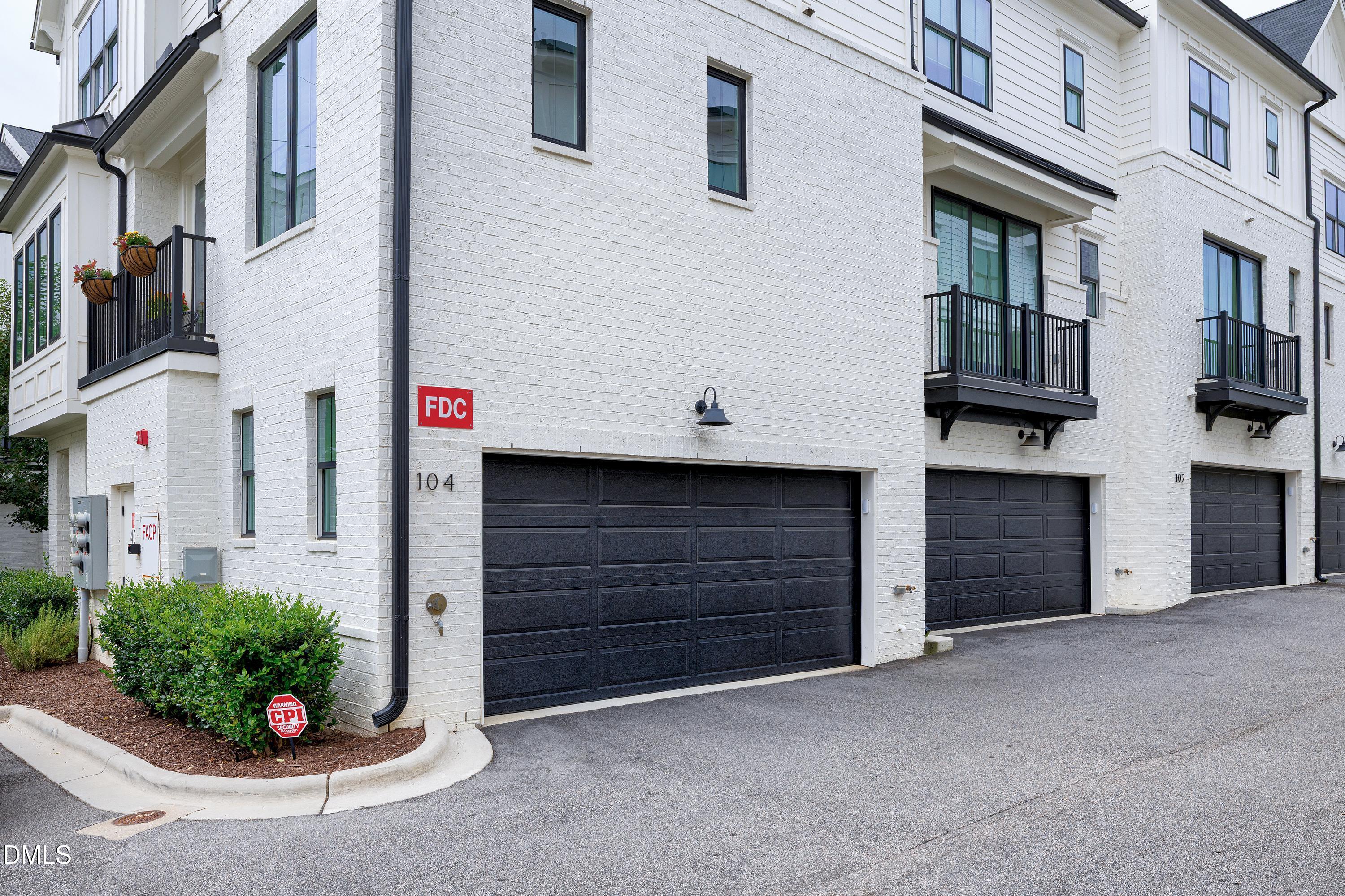 400 Bryan Pointe Drive, Unit 104 Raleigh, NC 27608 - Photo 49 of 66 a view of a house with a potted plant and garage