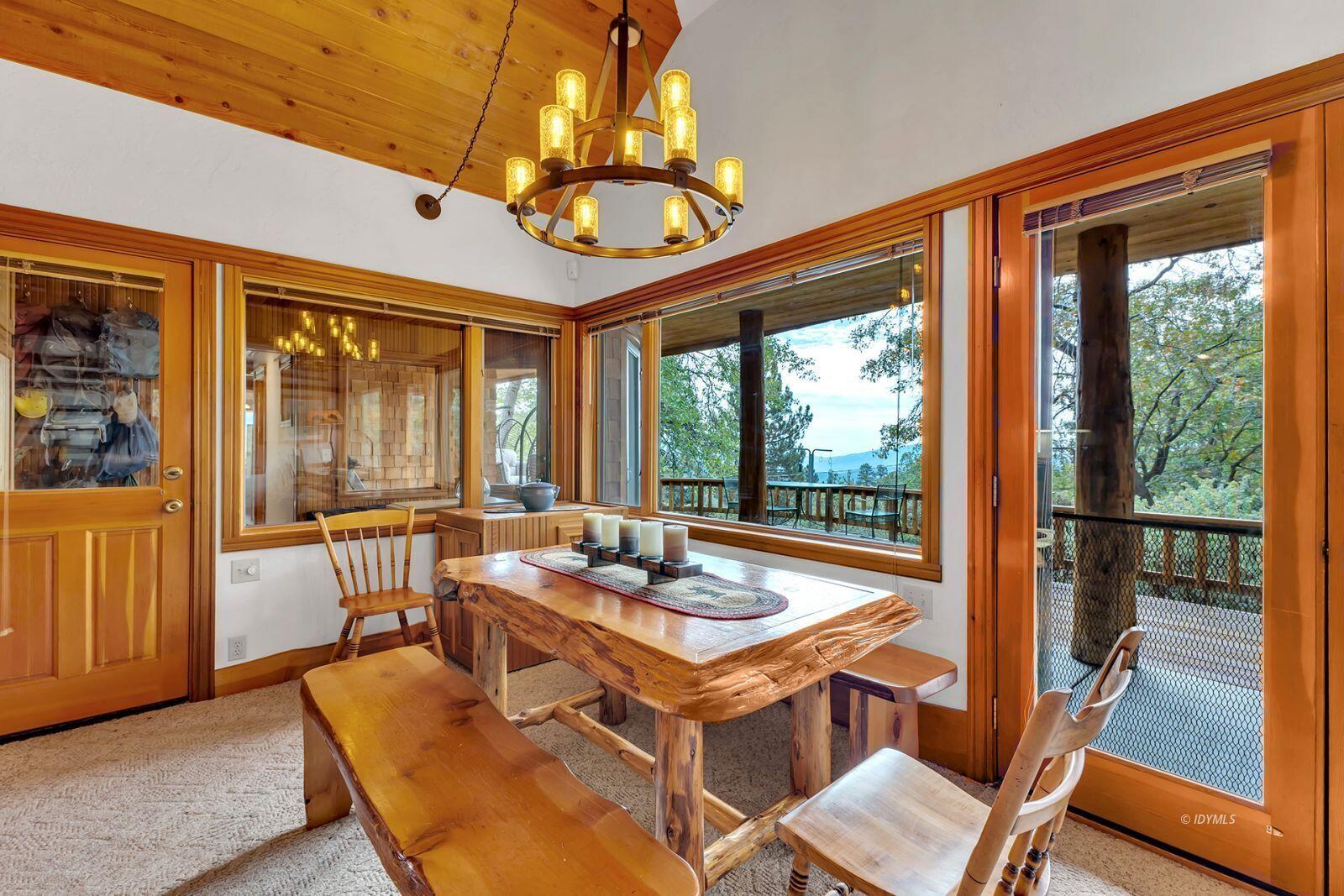 52980 Overlook Drive Idyllwild, CA 92549 - Photo 9 of 60 a view of a dining room with furniture large windows wooden floor and garden view