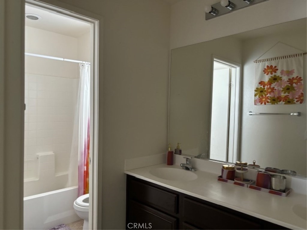 2090 Trinket Circle San Jacinto, CA 92582 - Photo 19 of 22 a bathroom with a granite countertop sink toilet and a mirror