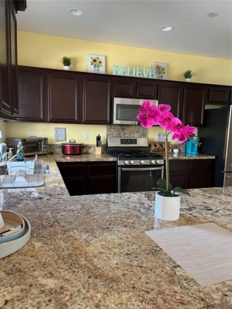 2090 Trinket Circle San Jacinto, CA 92582 - Photo 2 of 22 a kitchen with stainless steel appliances kitchen island granite countertop a sink and cabinets
