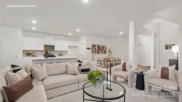 a living room with furniture kitchen and a dining table with kitchen view