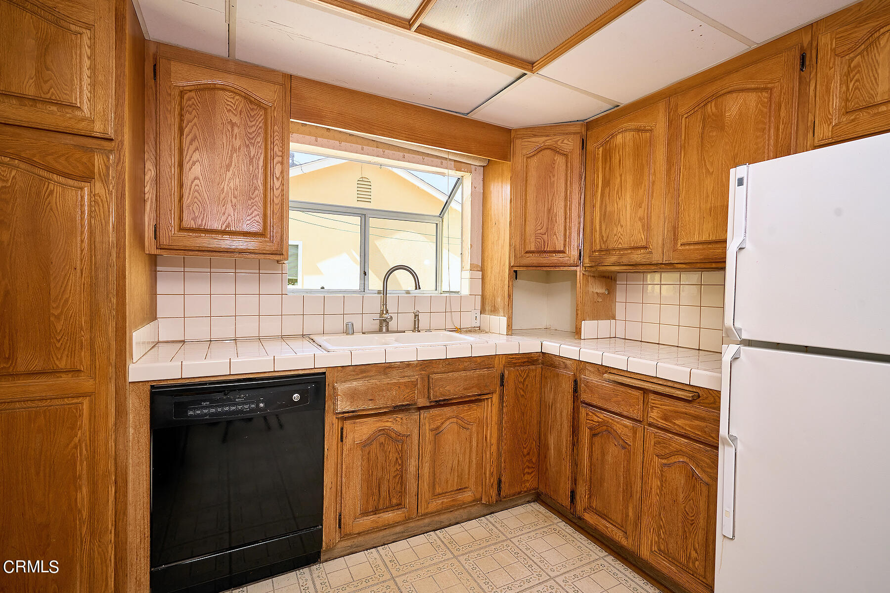 515 De Anza Way Oxnard, CA 93033 - Photo 9 of 48 a kitchen with a sink a refrigerator and cabinets
