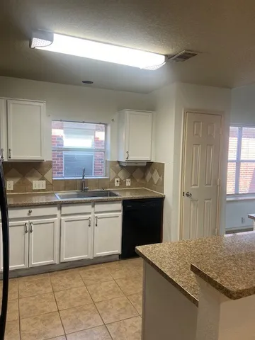 a kitchen with granite countertop sink and cabinets
