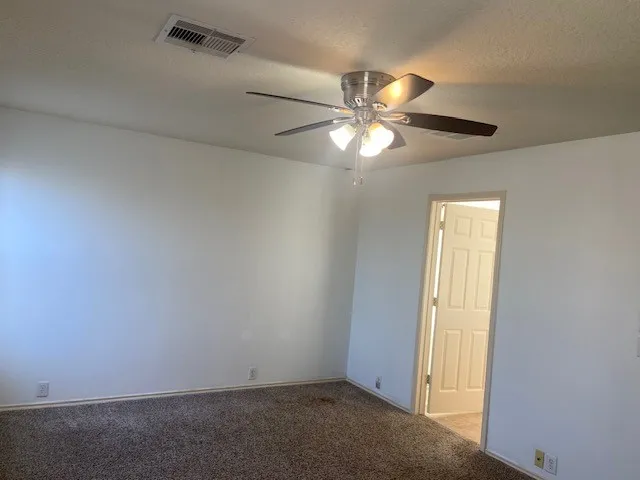 an empty room with closet and a chandelier fan