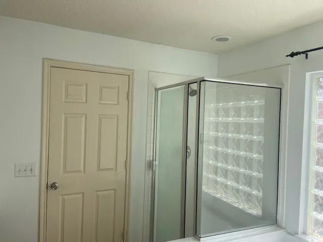 a bathroom with a glass shower door