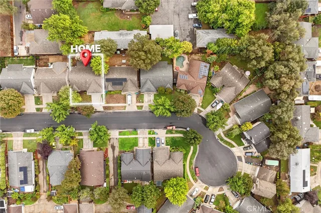 an aerial view of a house with a yard and a large tree