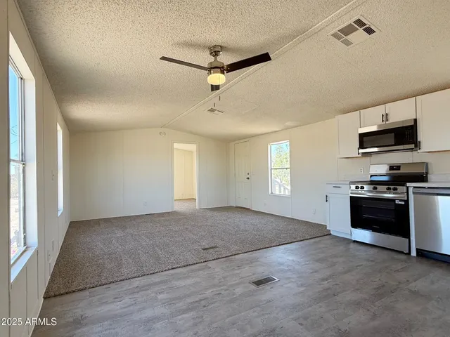 a view of a kitchen with a stove cabinets and a ceiling fan