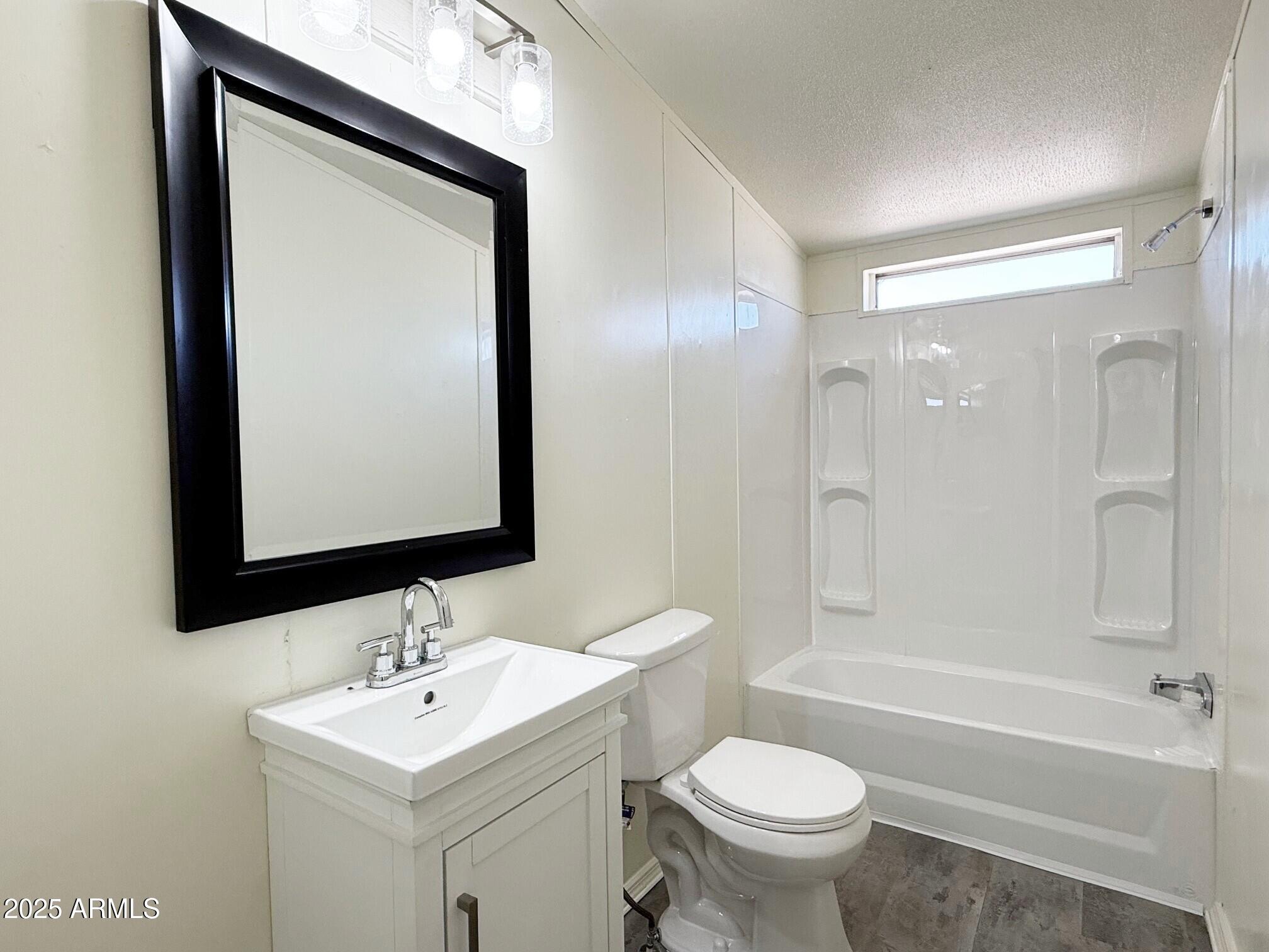 373 South Amarillo Valley Road Maricopa, AZ 85139 - Photo 17 of 23 a bathroom with a toilet sink and mirror