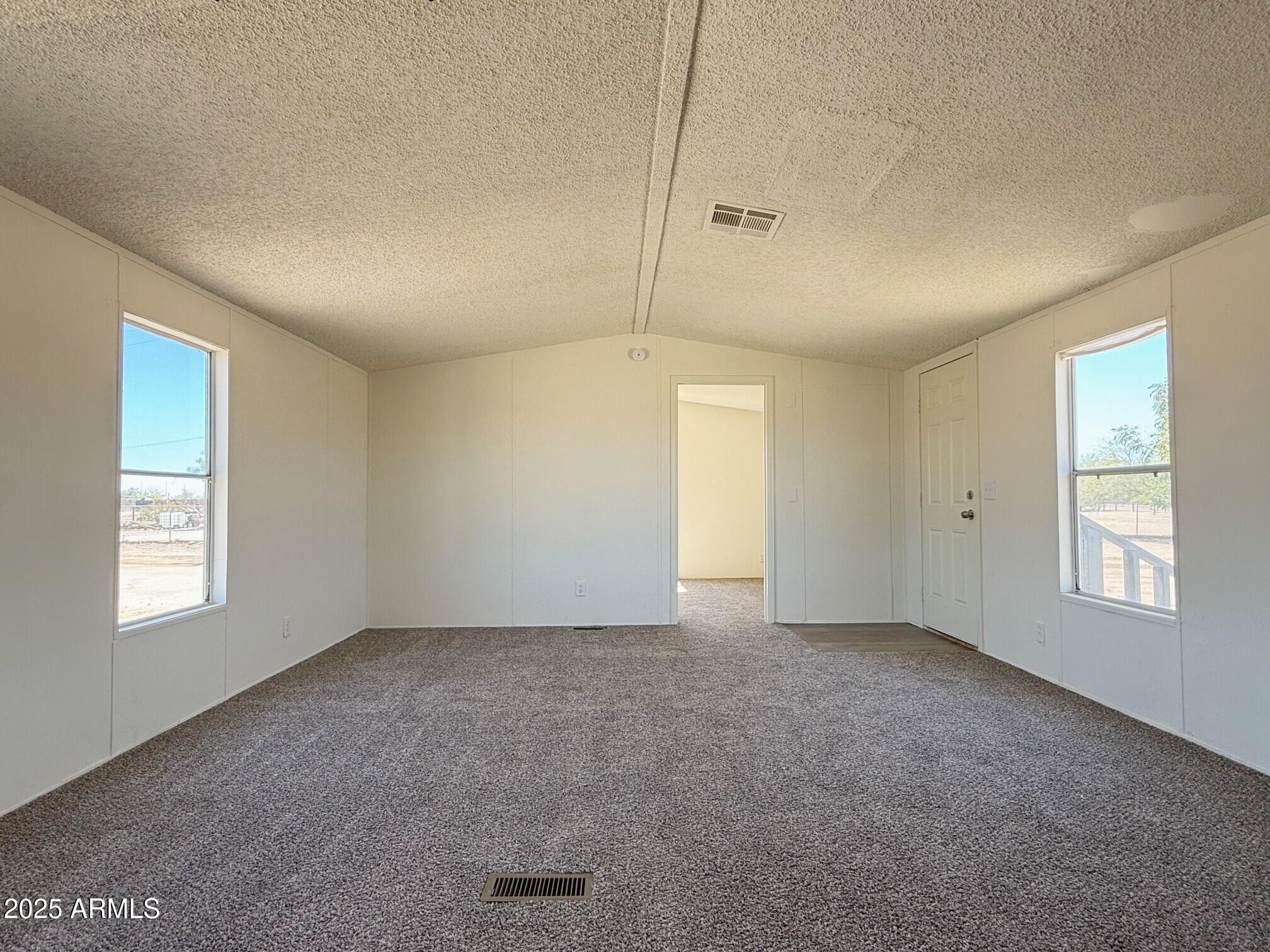 373 South Amarillo Valley Road Maricopa, AZ 85139 - Photo 7 of 23 a view of an empty room with window and closet area