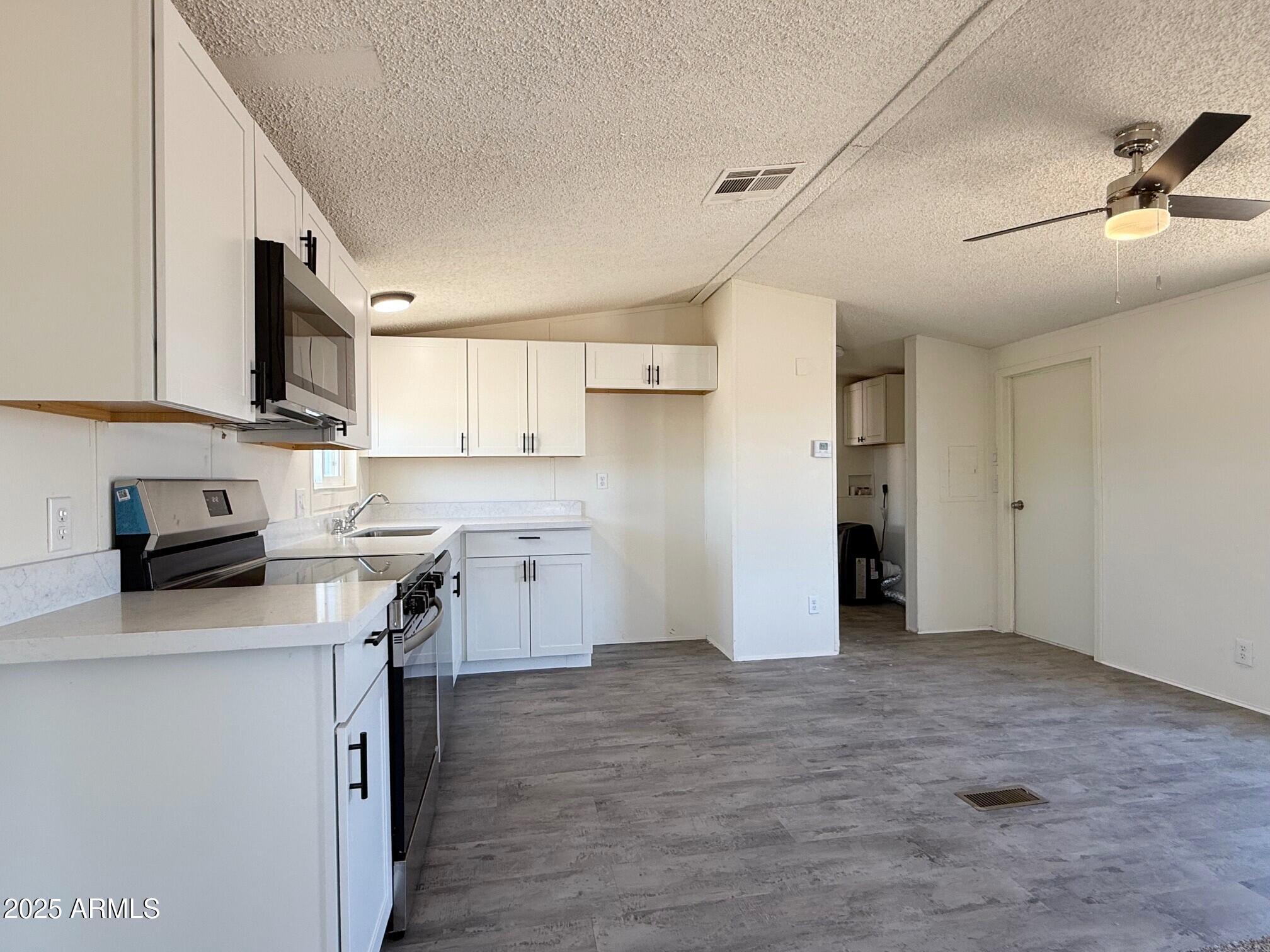 373 South Amarillo Valley Road Maricopa, AZ 85139 - Photo 10 of 23 a kitchen with a refrigerator a stove top oven a sink and dishwasher