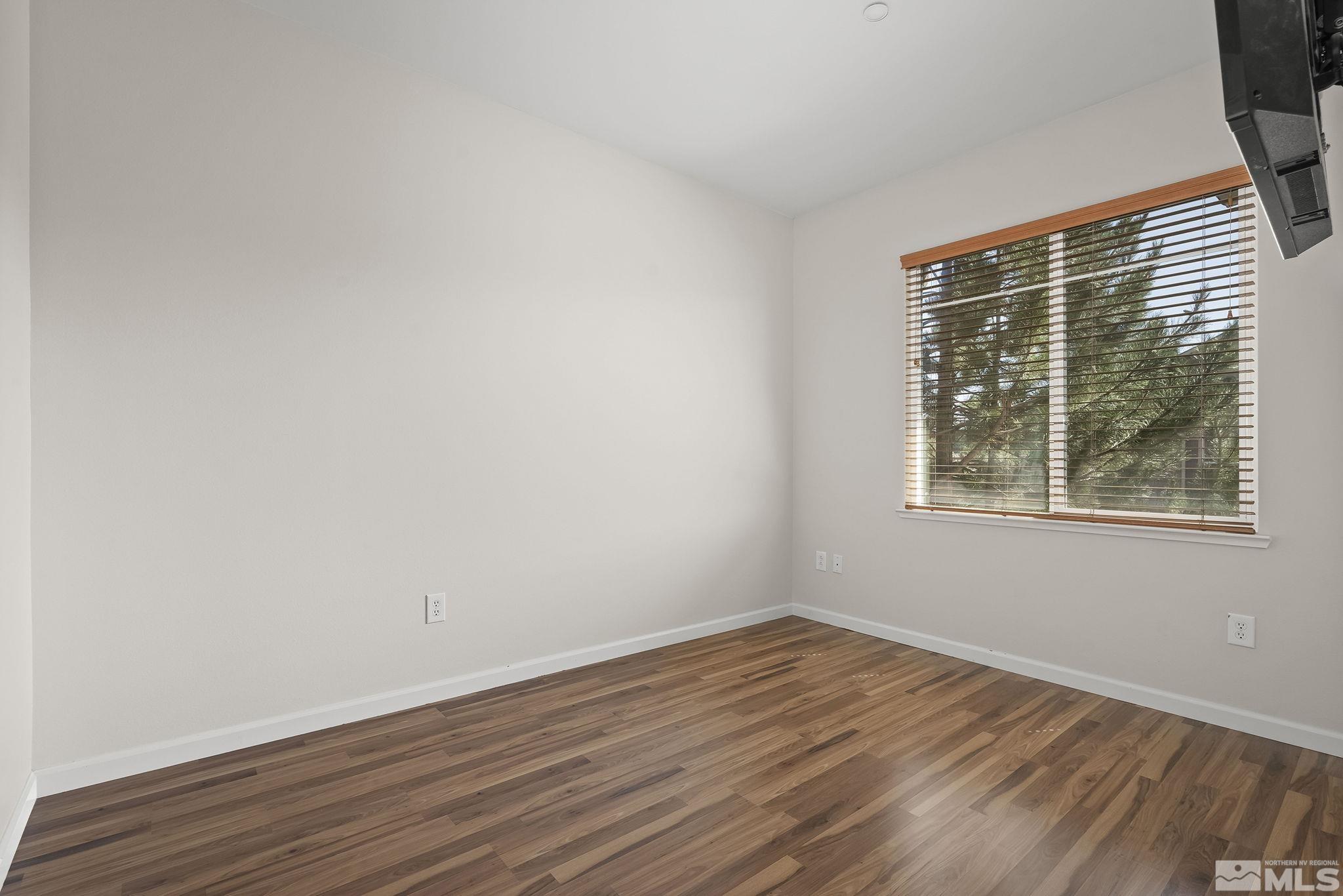 1450 Idlewild Drive, Unit 933 Reno, NV 89509 - Photo 14 of 32 a view of an empty room with wooden floor and a window